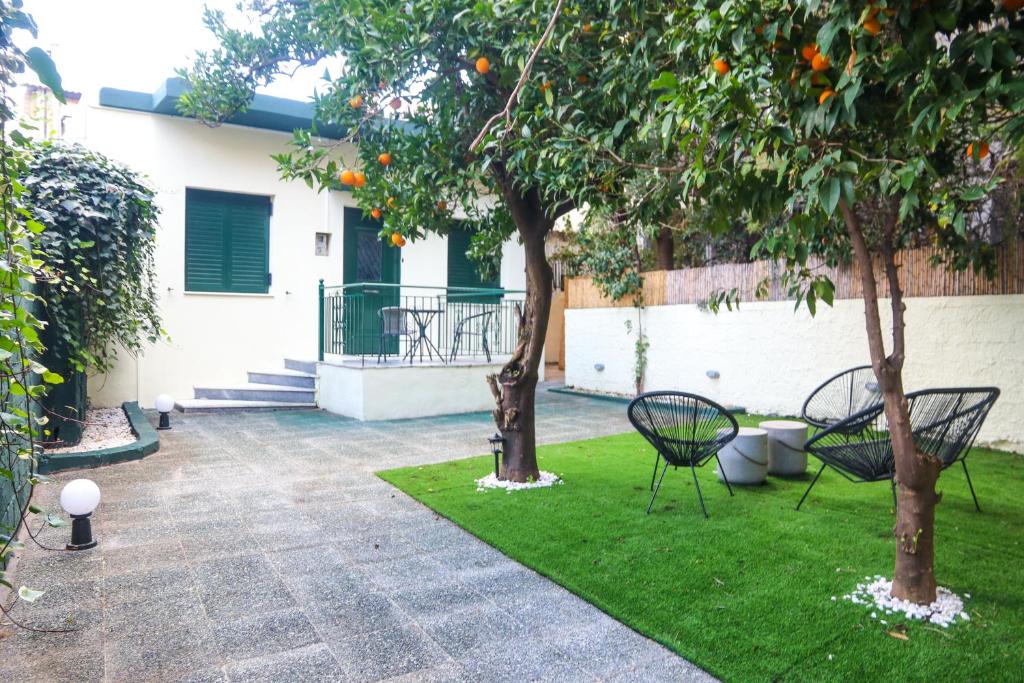 two chairs and an orange tree in a yard at Magical villa western peloponnese by MPS in Pyrgos
