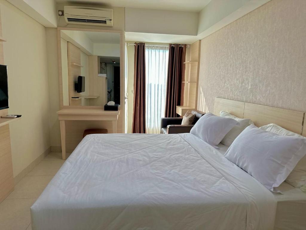 a large white bed in a hotel room at KUMU Lantai 18 Warhol Residence at Louis Kienne Simpang Lima Semarang in Semarang