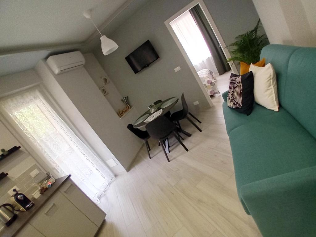 ein Wohnzimmer mit einem blauen Sofa und einem Tisch in der Unterkunft La Brezza Home in Sanremo