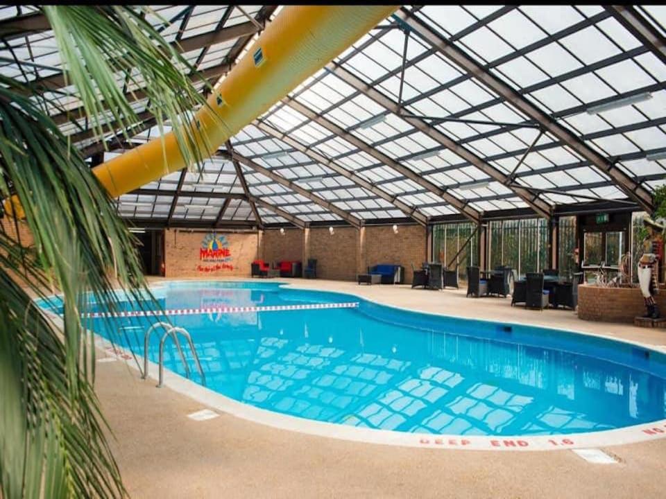 ein großer Pool mit Glasdach in der Unterkunft MDL Holiday Let in Rhyl
