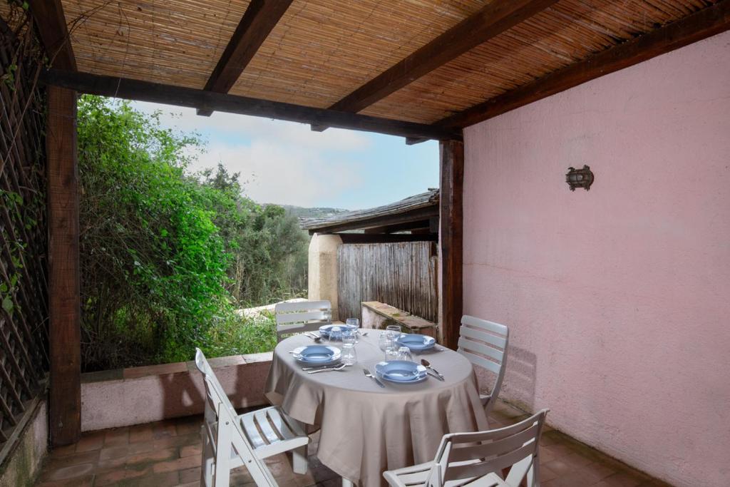 uma mesa e cadeiras no alpendre de uma casa em Casa Isidora by Wonderful Italy em Arzachena