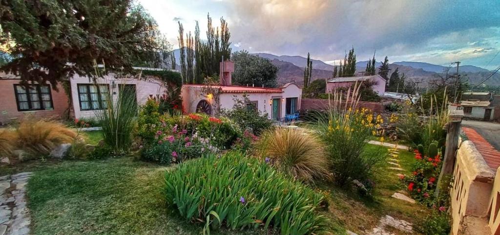 a house with a garden with flowers and plants at Los Arcabuceros Posada Boutique in Tilcara