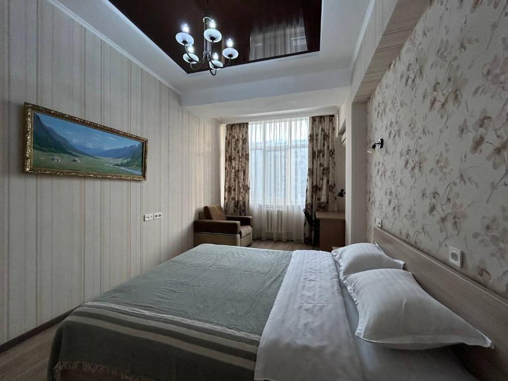 AURA on Ryskulov street 30 في بيشكيك: غرفة نوم بسرير ودهان على الحائط