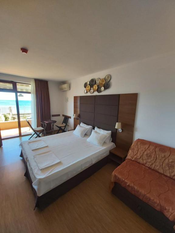 a hotel room with a bed and a couch at Guest House Skalite in Sozopol