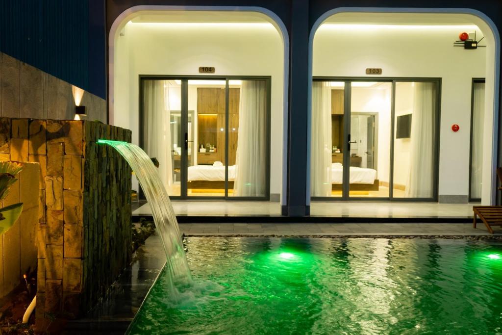 a swimming pool with a waterfall in a house at Hoàng Khang Hotel in Buôn Kô Sir