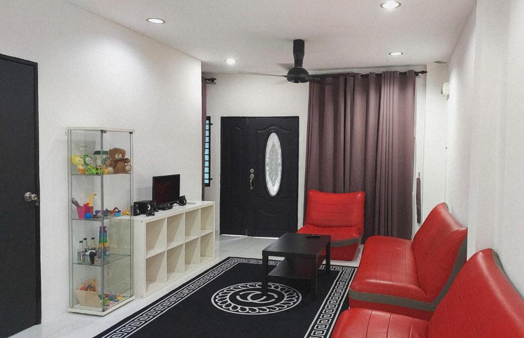 a living room with red chairs and a black door at D'Sandra Homestay in Kulim