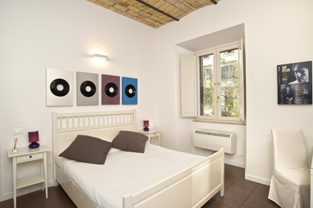 Un dormitorio blanco con una cama blanca y una ventana en Germanico Maxi, en Roma
