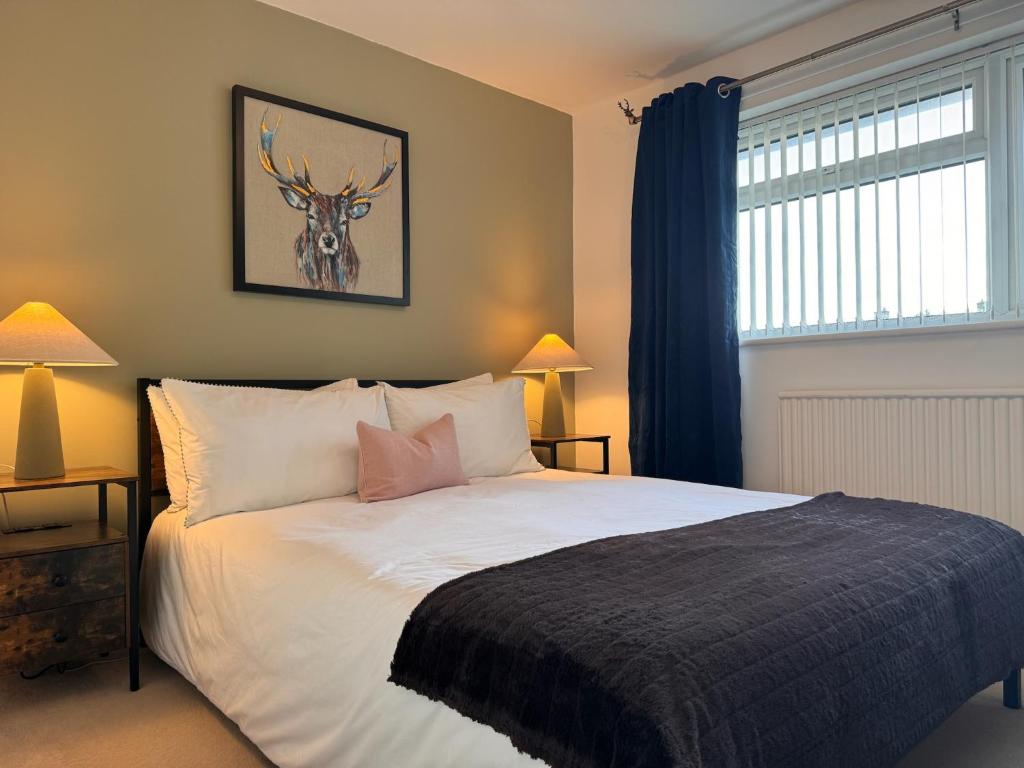 a bedroom with a bed with a deer picture on the wall at Ashvale, Cambridge in Chesterton