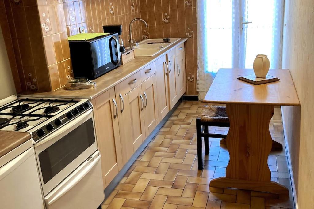 une cuisine avec un micro-ondes et une cuisinière four supérieur dans l'établissement Chez FERNAND-Vues sur les montagnes, à Arles-sur-Tech