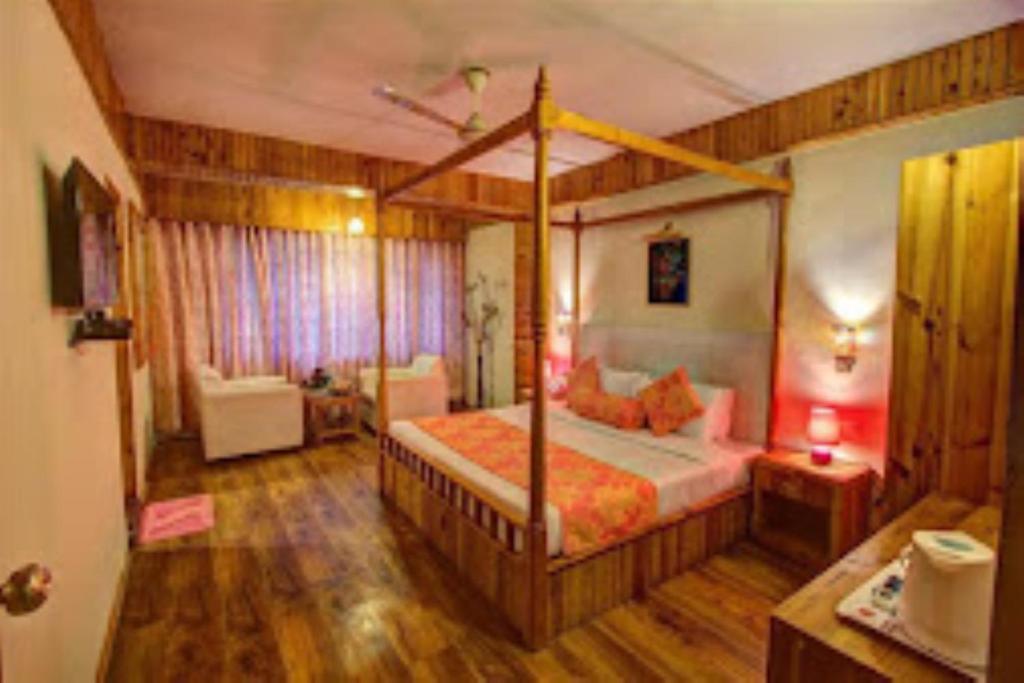 a bedroom with a canopy bed in a room at Hotel Apple Paradise Manali in Manāli