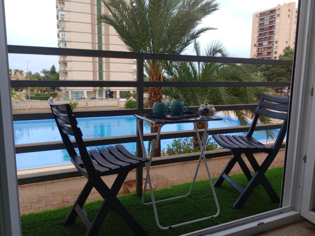 a table and chairs on a balcony with a pool at Paraíso Azul in Aguadulce