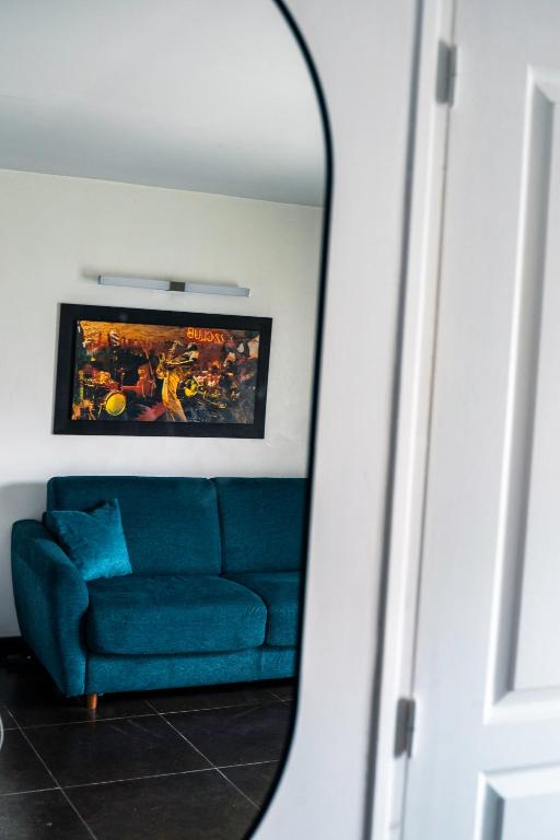 un canapé bleu dans un salon avec un miroir dans l'établissement Studio très agréable, à Neuilly-sur-Marne