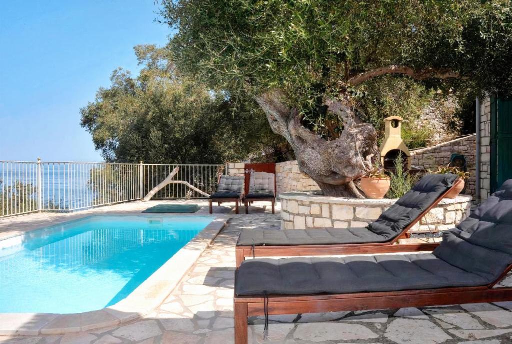 two lounge chairs next to a swimming pool at Villa Levrecchio in Longós