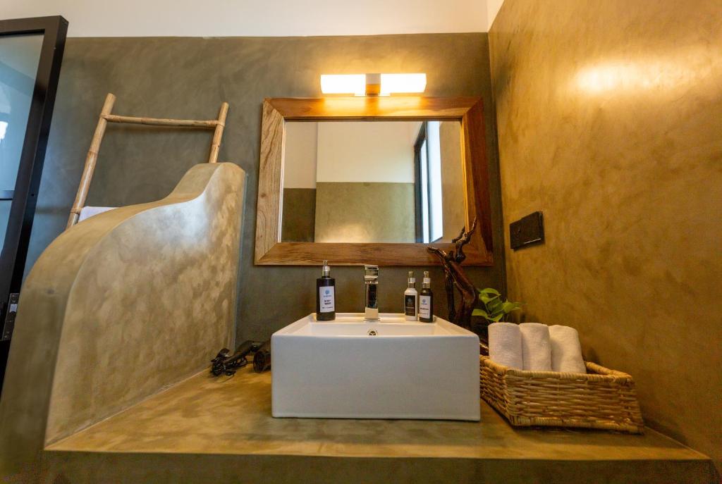 uma casa de banho com um lavatório branco e um espelho. em El DESTINO Hiriketiya em Dickwella