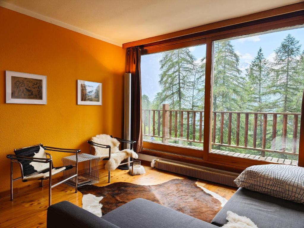 a living room with a large window and a balcony at Hostdomus - Sansicario R4 in Cesana Torinese