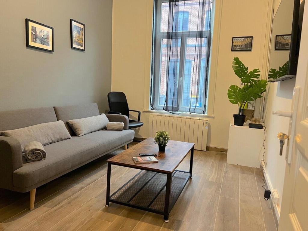 a living room with a couch and a coffee table at Maison Cosy 5 chambres 3 SDB proche Lille in Roubaix