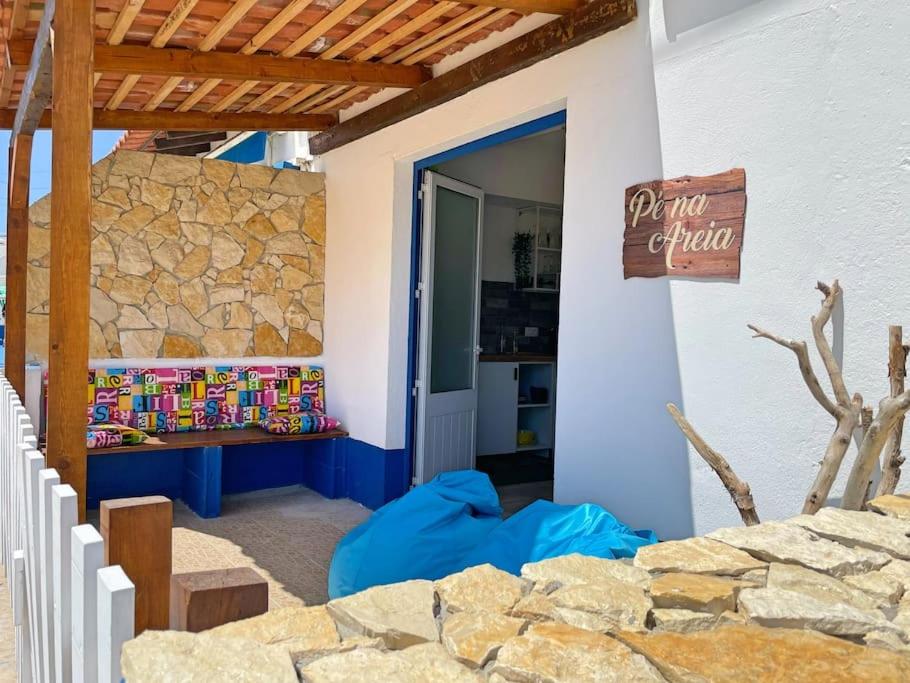 a patio of a house with a stone wall at Pé n' Areia by Ericeira Property in Carvoeira