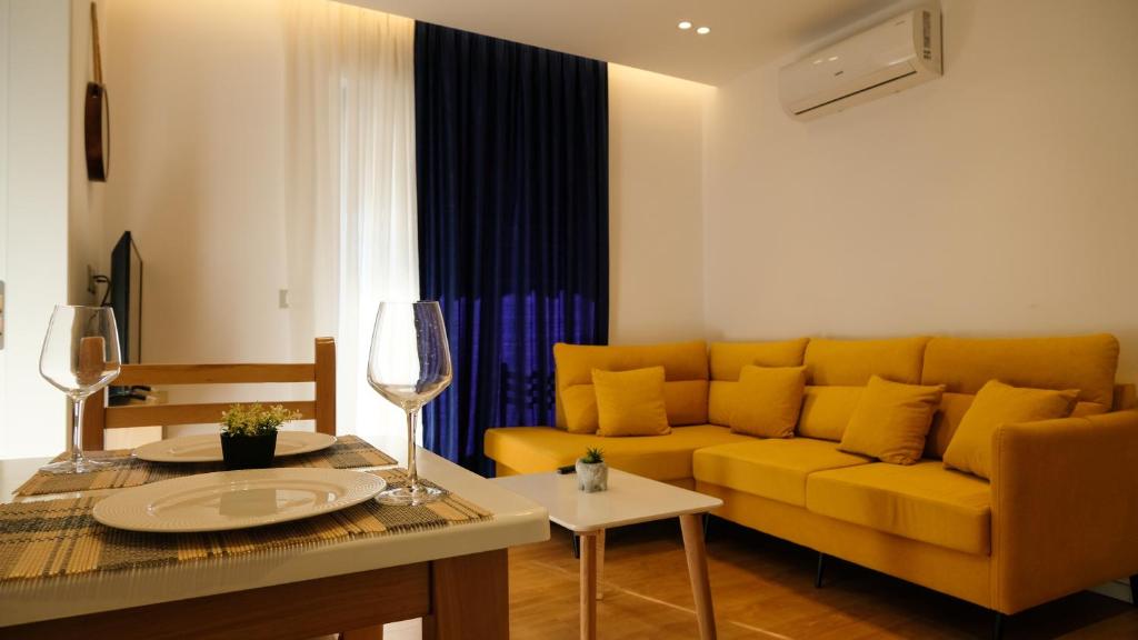 un soggiorno con un divano giallo e un tavolo di 2E Center Apartment a Tirana