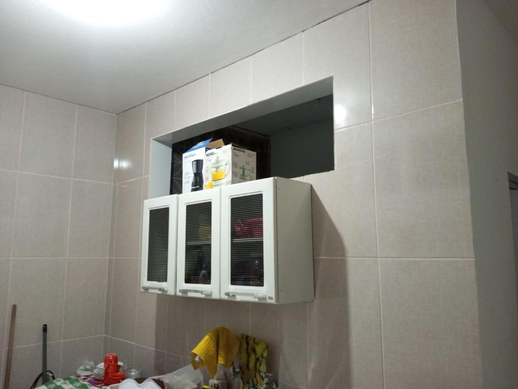 una cucina con forno a microonde su una parete piastrellata di Apartamento no Pelourinho a Salvador