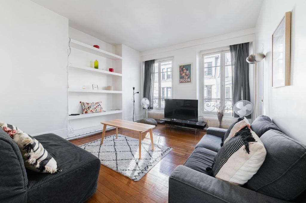 - un salon avec deux canapés et une table dans l'établissement Appartement Paisible Proximité des Halle - 4P, à Paris