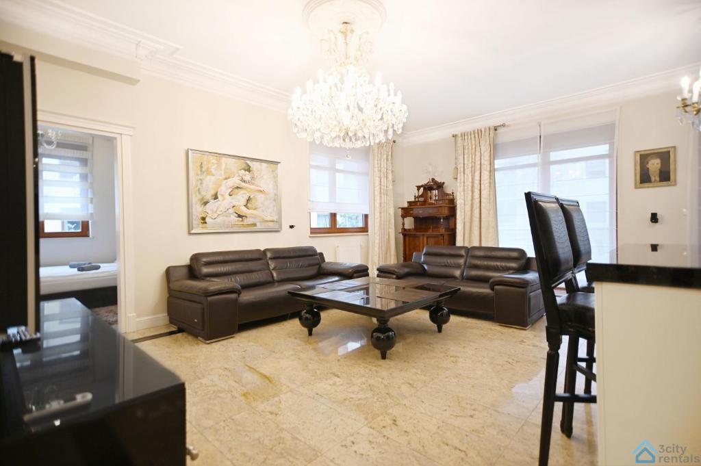 グダニスクにあるLarge and Luxury 3city Apartment in Gdańsk with Two Balconies by Noclegi Rentersのリビングルーム(革製家具、シャンデリア付)
