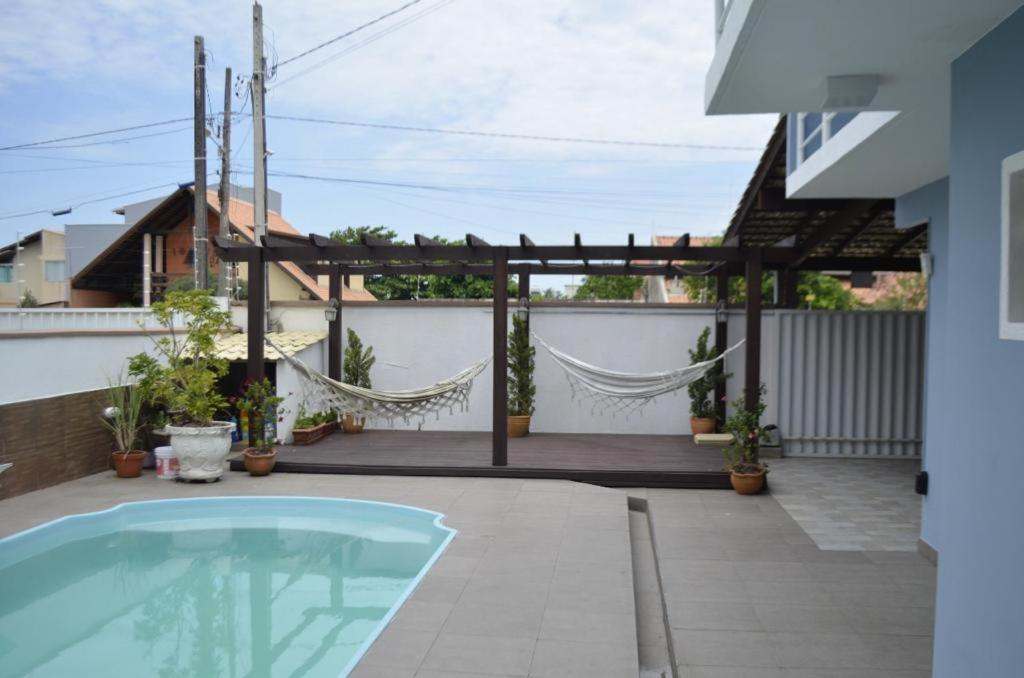 um quintal com uma piscina e uma pérgola em Casa de Alto Padrão próxima ao Beto Carrero em Navegantes