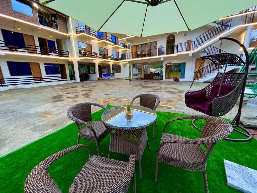 a table and chairs with an umbrella in a courtyard at Beach Valley View Resort in Candolim