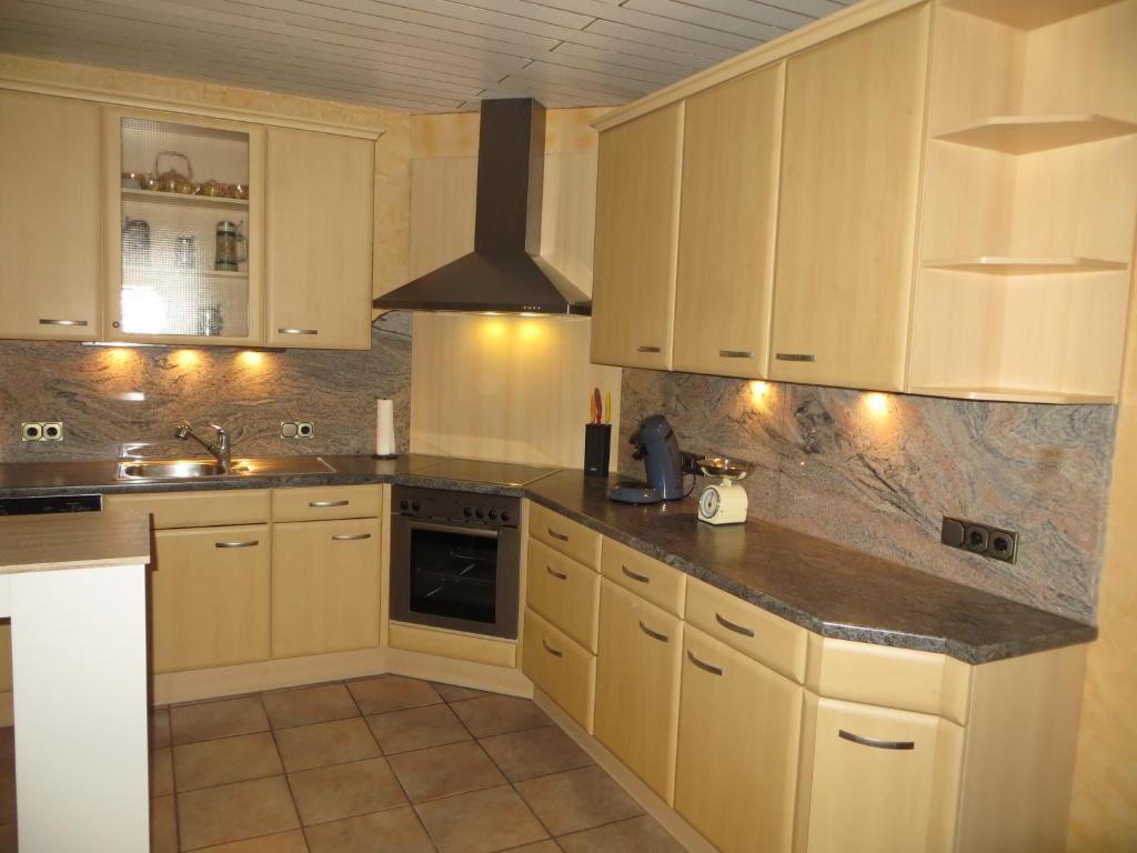 a kitchen with white cabinets and granite counter tops at Ferienwohnung Weinbachtal in Wallerfangen