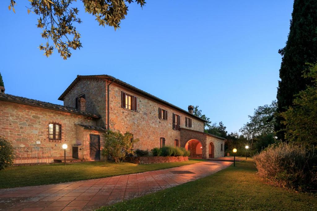 un antiguo edificio de piedra con un camino delante de él en Podere Fignano, holiday home - apartments, renovated 2024, en Montaione