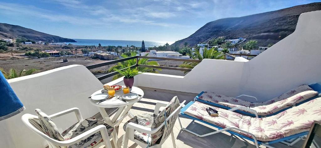 einen Balkon mit Stühlen und einem Tisch mit Meerblick in der Unterkunft Ferienwohnung Aurora in Giniginámar