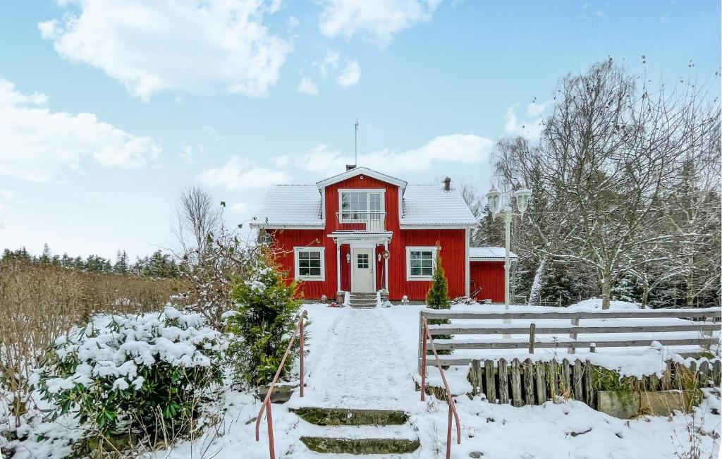 une maison rouge avec de la neige devant elle dans l'établissement Awesome Home In Anderstorp With House A Panoramic View, à Anderstorp