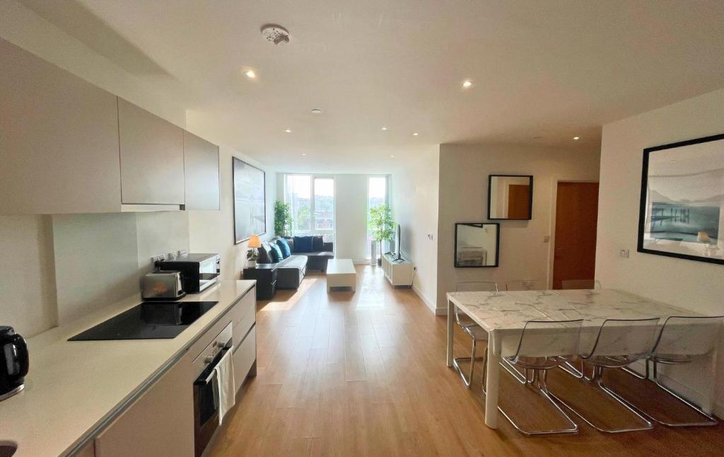 una cucina e un soggiorno con tavolo e divano di Bracknell RWH Beautiful Two Bedroom Apartment a Bracknell