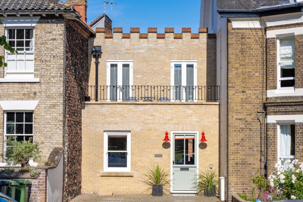 a brick house with a white door and balcony at Castle House 4 in Wells next the Sea