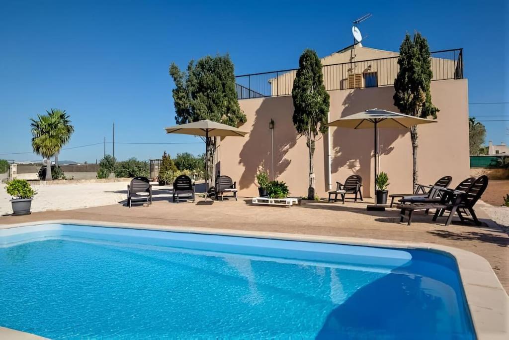 een zwembad voor een huis met stoelen en parasols bij Finca Es Trenc mit Pool I Whirlpool I BBQ I Klima in Campos