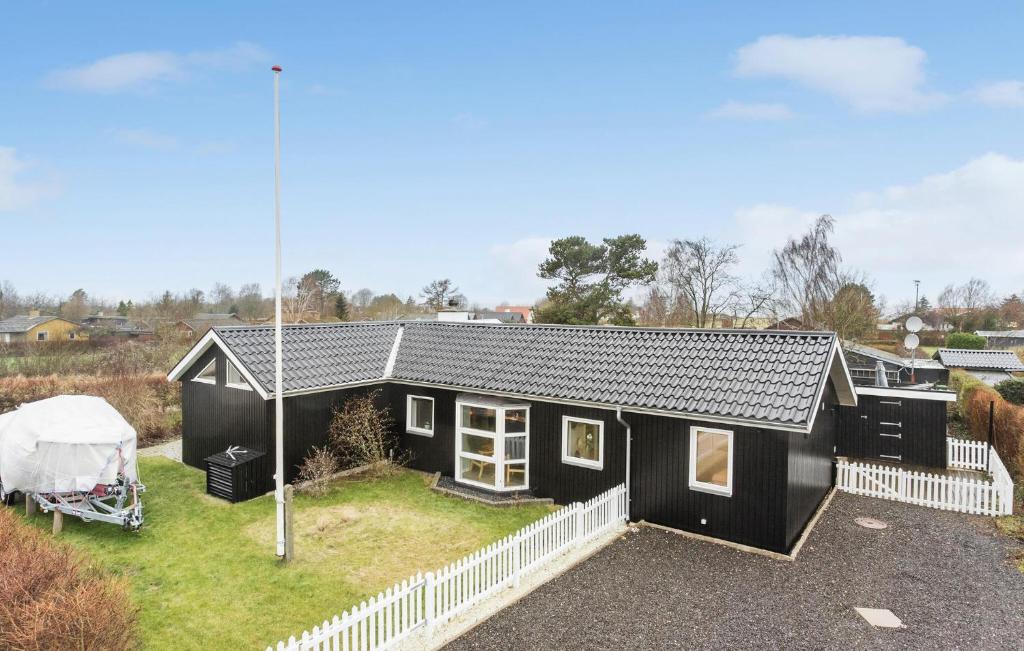 a black house with a white fence at Lovely Home In Bogense With Wifi in Bogense