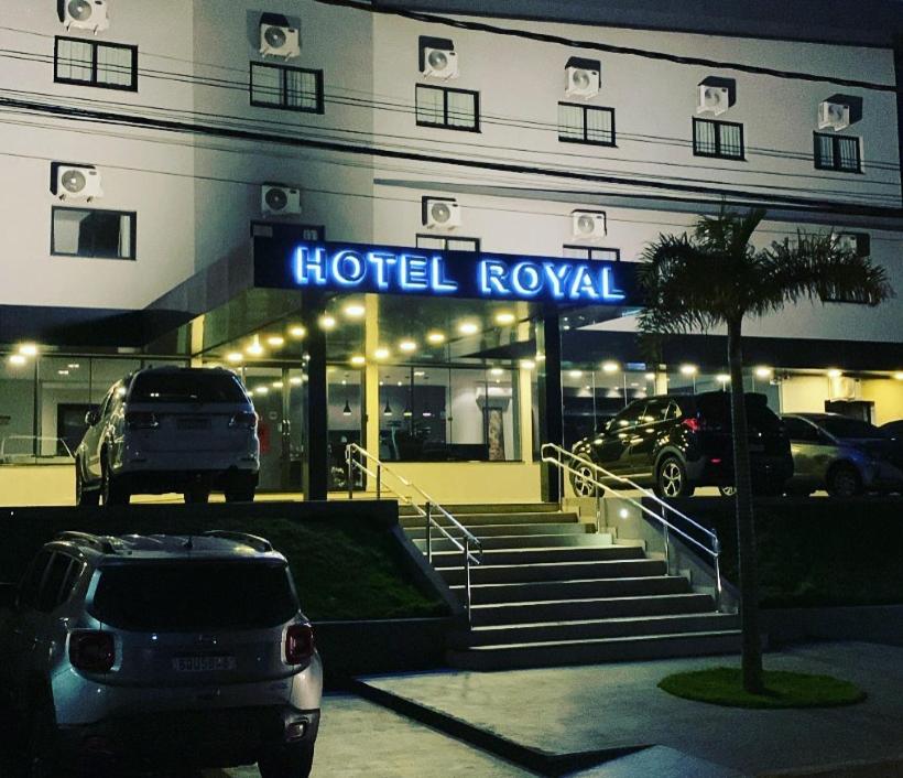 HOTEL ROYAL AMAMBAI في Amambaí: فندق ملكي بسيارات متوقفة في موقف سيارات