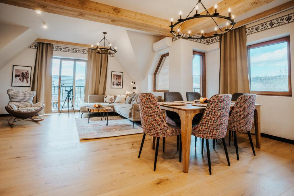 a dining room and living room with a table and chairs at VisitZakopane - Premium Best View&Spa Apartment in Zakopane