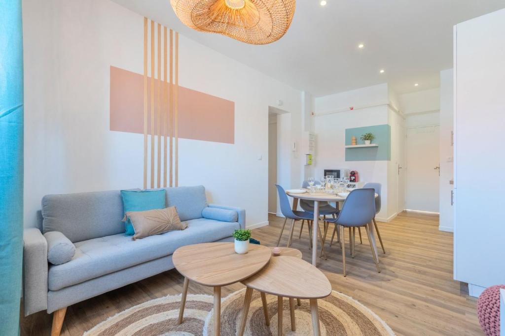 un salon avec un canapé bleu et une table dans l'établissement 2 bedroom apartment near tram, CHR + parking, à Roubaix