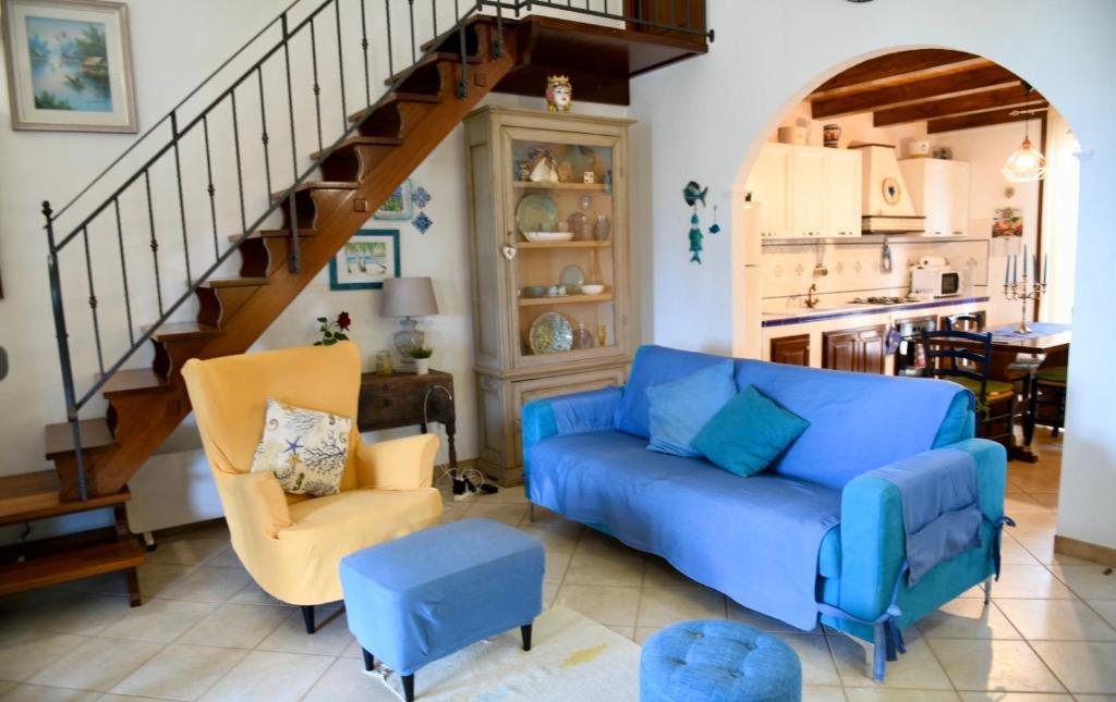 sala de estar con sofá azul y escalera en Azzurro Mare - Cornino, en Custonaci