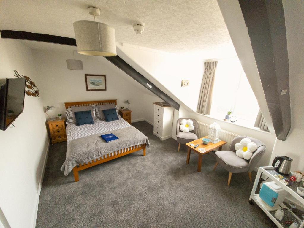 a bedroom with a large bed and a staircase at Beachcomber B&B in Tenby