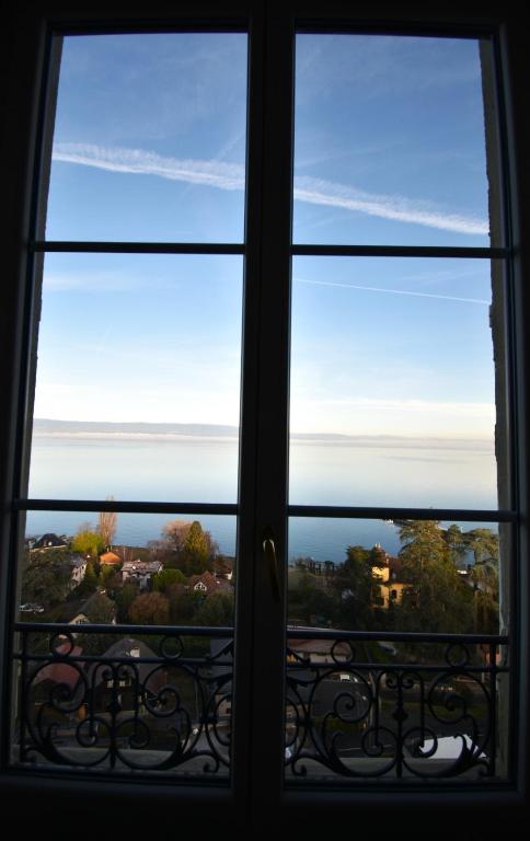 a window looking out at the view from a house at Appartement avec vue 180 sur le Lac Léman in Thonon-les-Bains