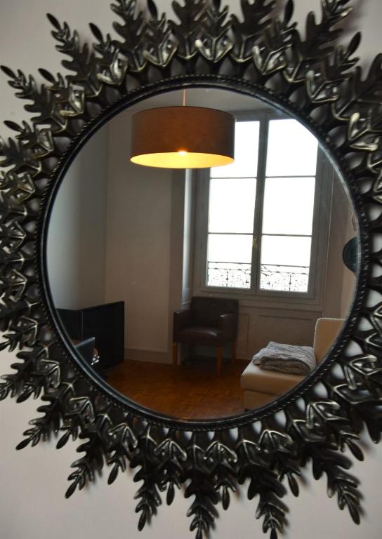 a mirror on the wall of a living room at Appartement avec vue 180 sur le Lac Léman in Thonon-les-Bains