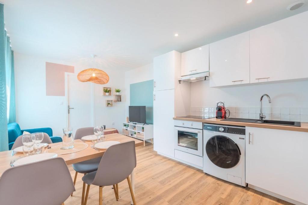 a kitchen and dining room with a table and chairs at 1 bedroom apartment near tram, CHR + parking in Roubaix