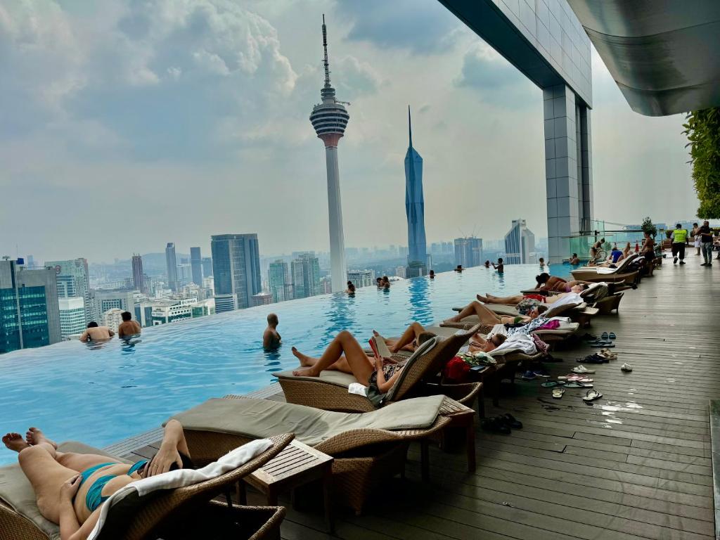 um grupo de pessoas deitadas numa piscina num edifício em Platinum Suites KLCC by Classy em Kuala Lumpur
