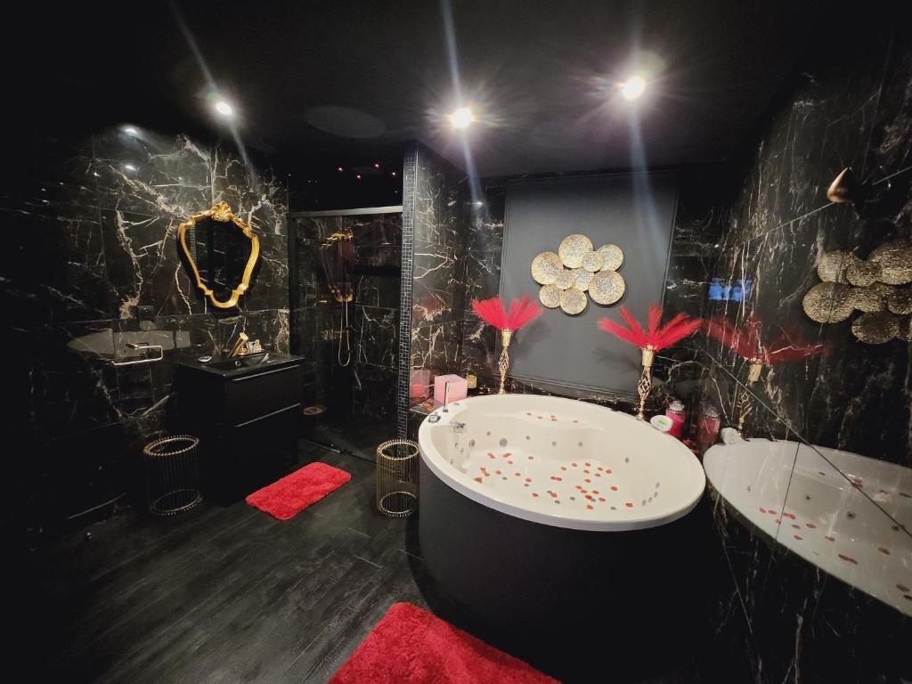 een badkamer met een bad en 2 wastafels bij O' Plaisirs Interdits - Loveroom in Caen