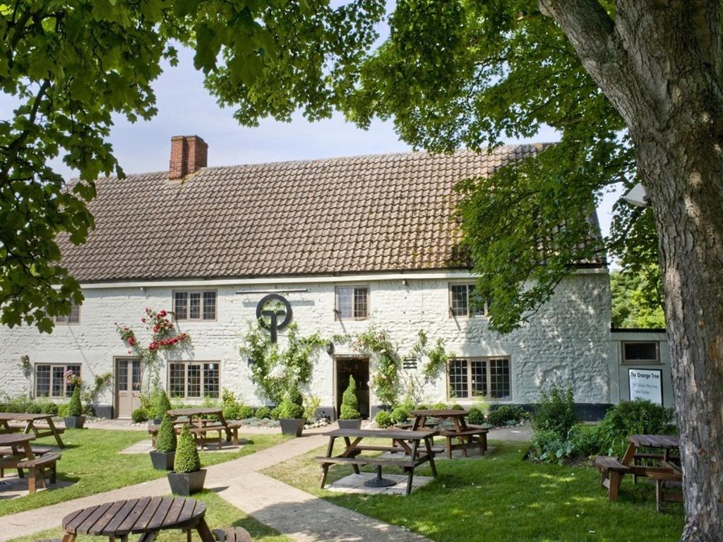 un edificio blanco con mesas de picnic delante en The Orange Tree Thornham, en Thornham