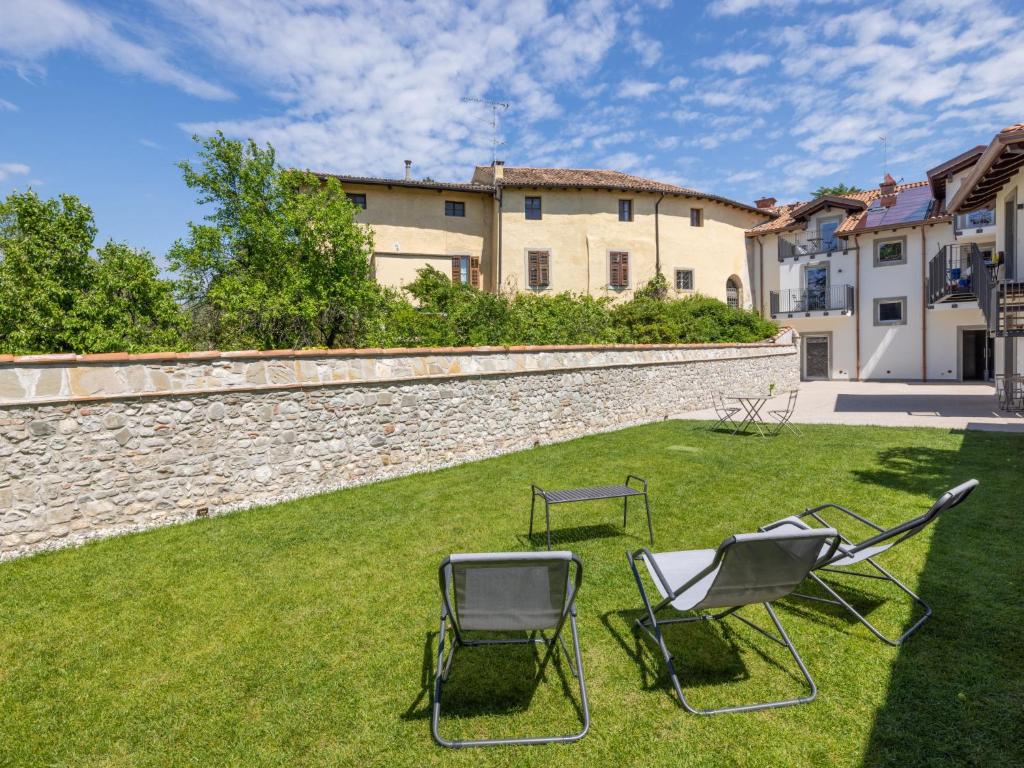 deux chaises assises sur une pelouse devant un mur dans l'établissement Apartment Il Giardino Segreto-7 by Interhome, à Cividale del Friuli