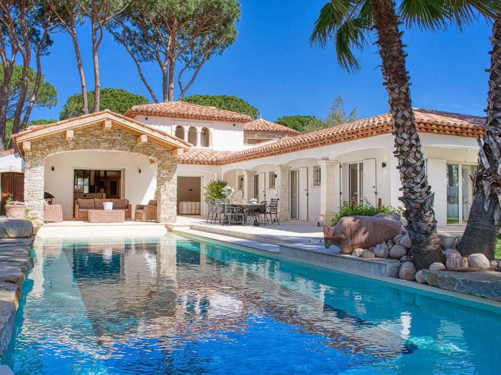 uma piscina em frente a uma casa com palmeiras em Villa Célalie by Interhome em Cogolin