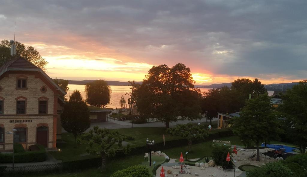 uma vista de um edifício com um pôr-do-sol ao fundo em Ferienwohnung und Pension Antje Ekert em Uhldingen-Mühlhofen