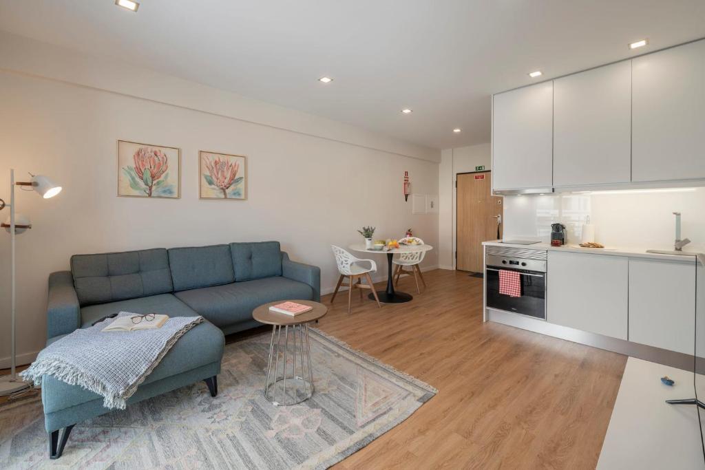 a living room with a blue couch and a kitchen at Santa Luzia III by An Island Apart in Funchal